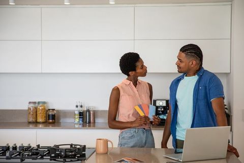 Couple Discuss Paint Options in Modern Kitchen Interior