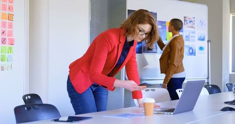 Businesswoman Engaging with Mobile Phone and Laptop in Office