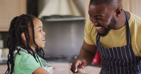 Smiling Father and Daughter Baking Together in Kitchen