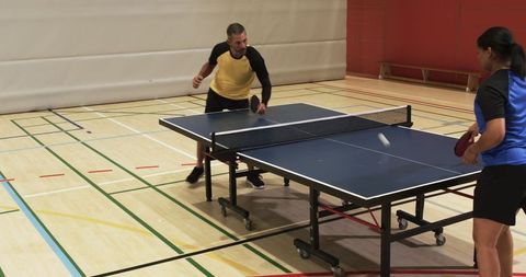 Competitive Table Tennis Match in Sports Hall