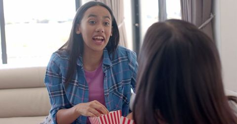 Teen Girls Enjoying Movie and Popcorn at Home