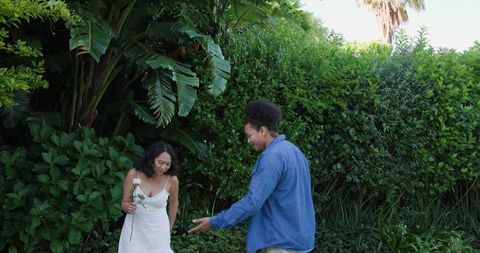 Romantic Couple Enjoying Outdoor Picnic with Flower in Lush Garden