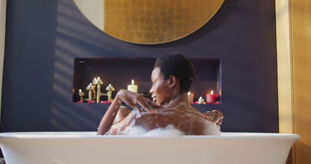 Happy african american woman taking bath in bathroom. domestic life, spending time and relaxing at home.