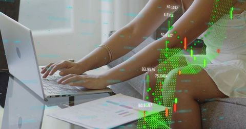 Chinese woman typing on laptop with financial charts and green data overlays