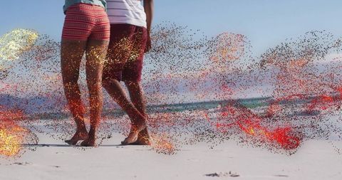 Barefoot Couple Walking on Sunny Beach Creating Footprints