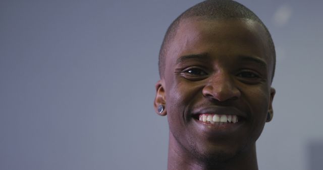 Young Man Smiling with Ear Studs on Grey Background - Download Free Stock Images Pikwizard.com