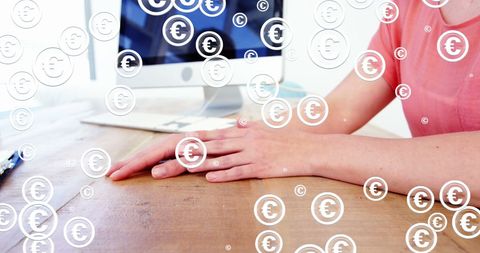 Businessman at desk with digital euro symbols overlay