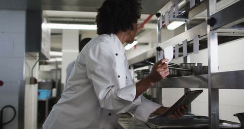 Chef receiving orders in busy restaurant kitchen