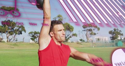 Athlete lifting medicine ball overhead on sports field with magenta analytics overlay