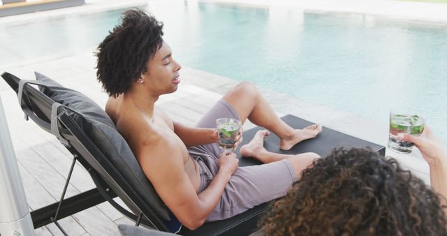 Young Man Relaxing by Poolside with Refreshing Drink - Download Free Stock Images Pikwizard.com