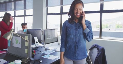Happy Businesswoman Talking on Smartphone in Modern Office
