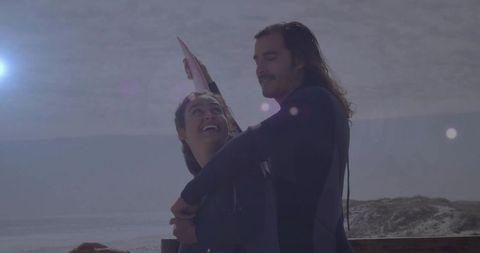 Surfers holding board on coastal boardwalk