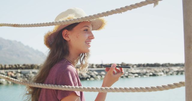 Young woman enjoying the outdoors while writing by the sea - Download Free Stock Images Pikwizard.com