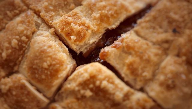 Golden lattice fruit pie slice revealing glossy jam and sugar-crust texture