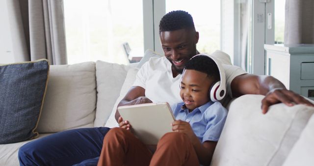 Father and Son Bonding with Tablet and Headphones on Couch - Download Free Stock Images Pikwizard.com