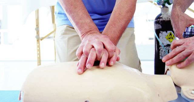 Sessions like these are crucial for teaching first aid techniques and are suitable for healthcare professional development materials, medical training resources, or emergency preparedness guides. The image provides a clear visual of CPR hand placement and technique, making it useful for instructional manuals and emergency responder training programs.