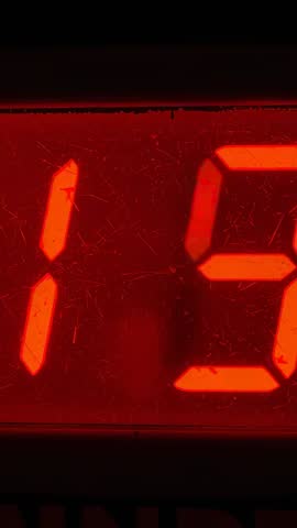 Vertical close-up showing red seven-segment LED readout glowing through scratched dusty bezel