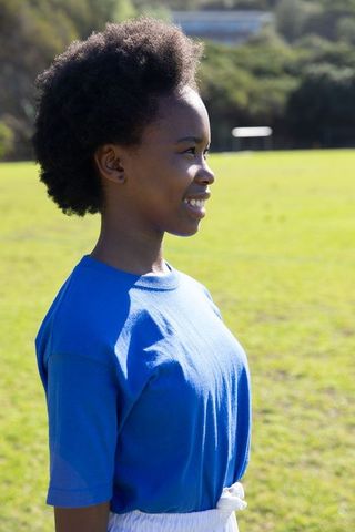 Confident teen girl in athletic outfit at soccer field