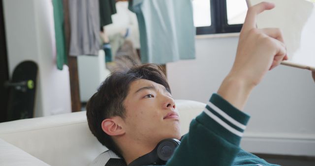 Young Man Lying on Couch Watching Tablet - Download Free Stock Images Pikwizard.com