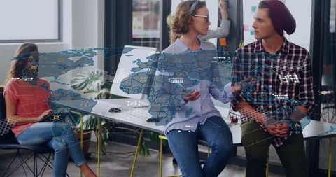 Young Professionals Discussing Strategy with Digital World Map Overlay