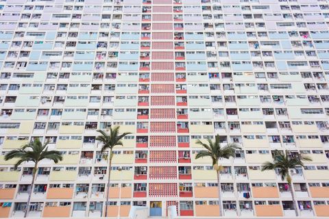 Colorful facade of residential condo building with palm trees