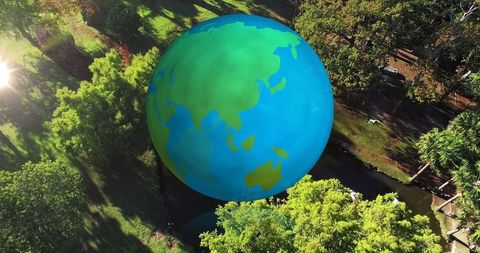 Spinning Globe Above Verdant Landscape Celebrating Earth Day