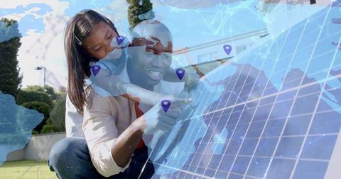 Parent and child installing solar panel in backyard, learning renewable energy together