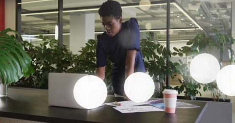 Professional Woman Focusing on Laptop in Modern Office Environment