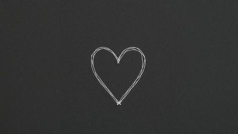 Minimalist hand-drawn heart on dark chalkboard background