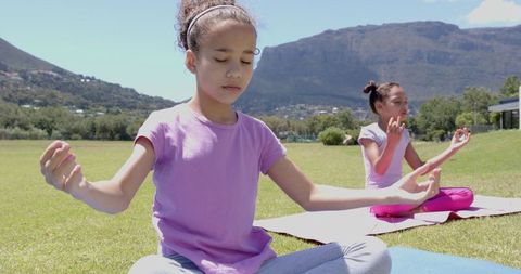 Girls Meditating in Outdoor Yoga Setting with Majestic Mountain Views