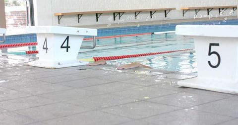 Competitive swimmer reaching indoor pool wall between lanes 4 and 5 during lap training
