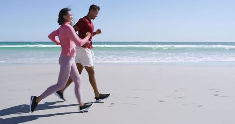 Active Couple Jogging on Sandy Shore at Low Tide Under Clear Sky for Coastal Fitness and Wellness