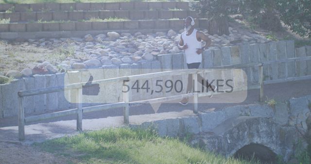 A man running in an outdoor park while wearing headphones. He is next to a stone bridge, surrounded by greenery and stone steps. The overlay showing 544,590 likes suggests a social media theme. Perfect for topics related to outdoor fitness, social media influence on lifestyle, physical exercise, and health.