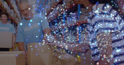 Volunteers Packing Donations in Warehouse with Glitter Effect Overlay