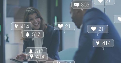 Smiling businesswoman holding tablet while colleague discussing social engagement in office lounge
