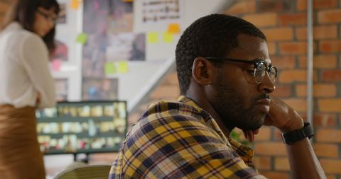 Focused graphic designer contemplating inspiration in creative office