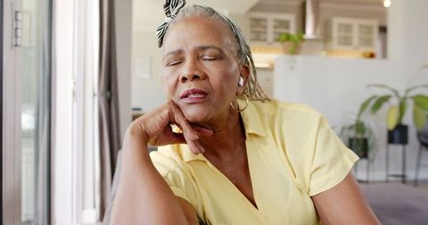 Senior Woman Relaxing at Home with Eyes Closed