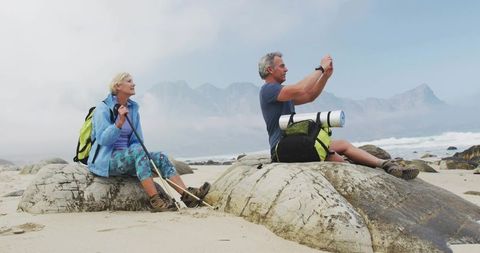 Senior couple enjoying scenic beach and mountain hiking