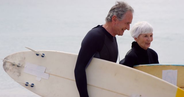 Elderly Couple Surfing at Beach in Wetsuits with Surfboards - Download Free Stock Images Pikwizard.com
