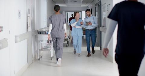 Healthcare Professionals Walking Hospital Corridor Discussing Patient Care