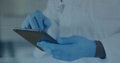 Clinician tapping tablet with blue nitrile gloves wearing white labcoat for digital health