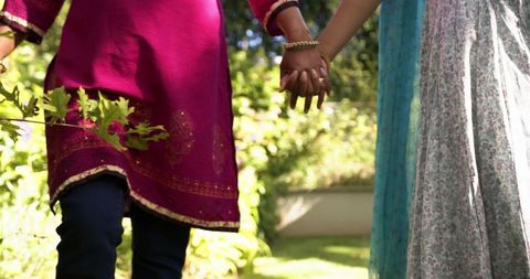 Indian couple walking holding hands in traditional sari