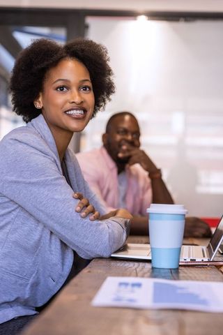Colleagues Collaborating in Modern Office with Coffee and Laptops