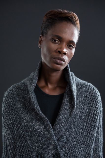 Portrait of androgynous man in sweater against grey background