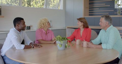 Diverse Family Bonding Cheerfully Around Kitchen Table