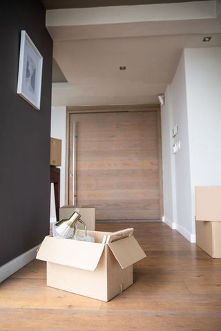 Cardboard box and lamp in modern home entrance hall