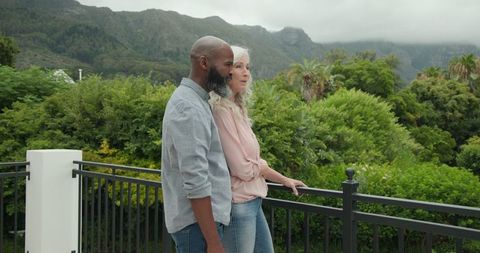 Couple Relaxing and Enjoying Scenic Mountain View from Balcony