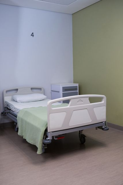 This image shows an empty hospital bed in a clean and well-maintained ward. It can be used in healthcare-related articles, medical facility brochures, and patient care guides to depict a clinical environment. It is also suitable for illustrating topics related to hospital stays, healthcare services, and medical care.