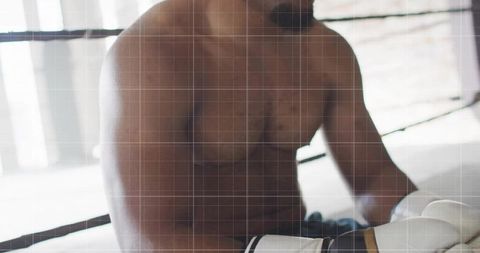 Shirtless Boxer Resting In Gym Ring Wearing Boxing Gloves With Cords