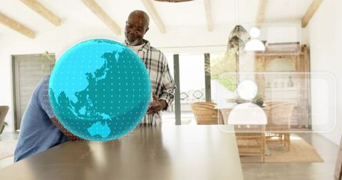 Senior exploring holographic globe at kitchen island with augmented reality ui